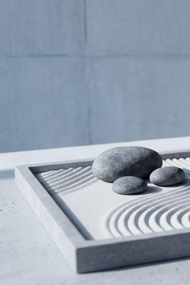 Miniature zen garden with grey stones on raked sand
