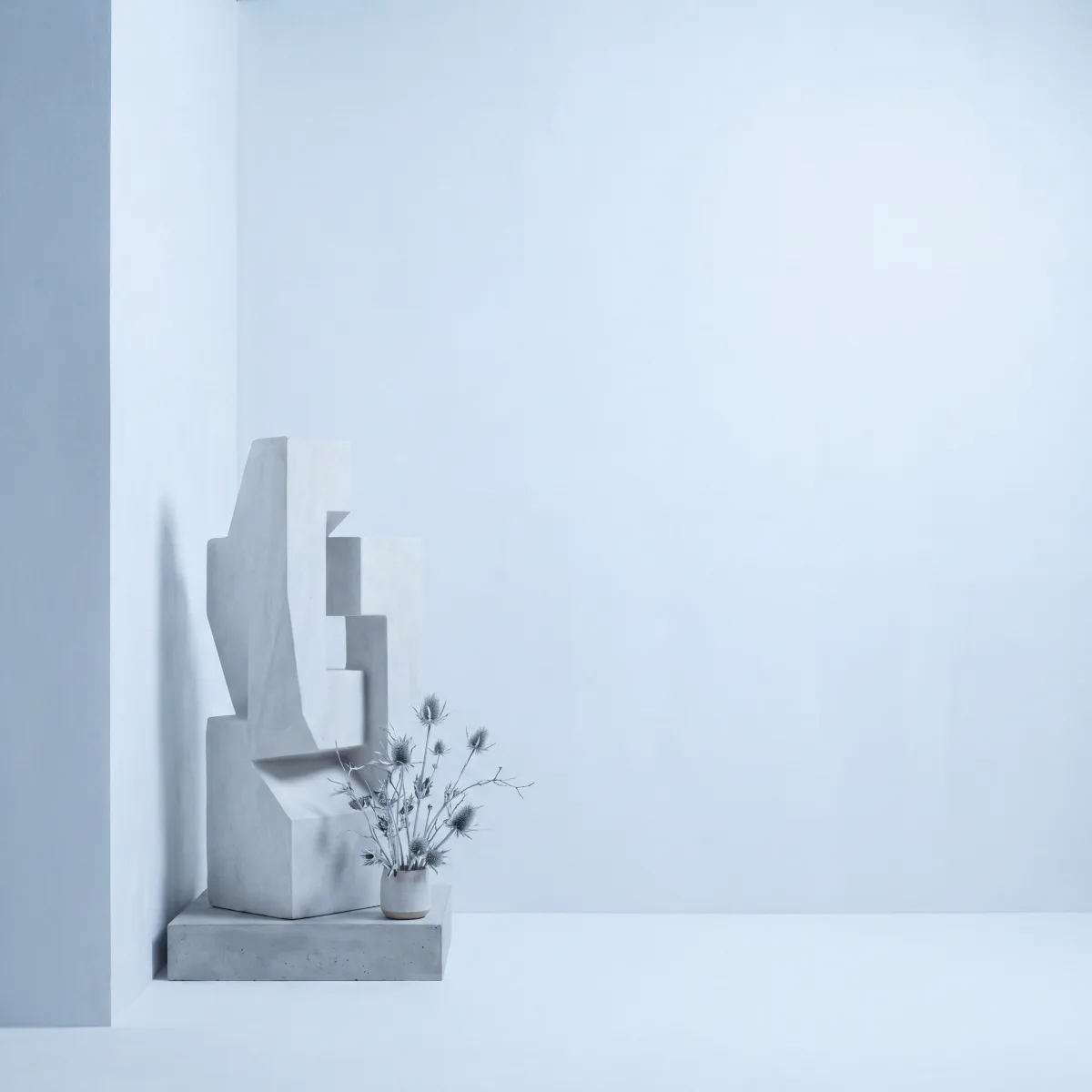 White geometric blocks and dried stems in a bright room