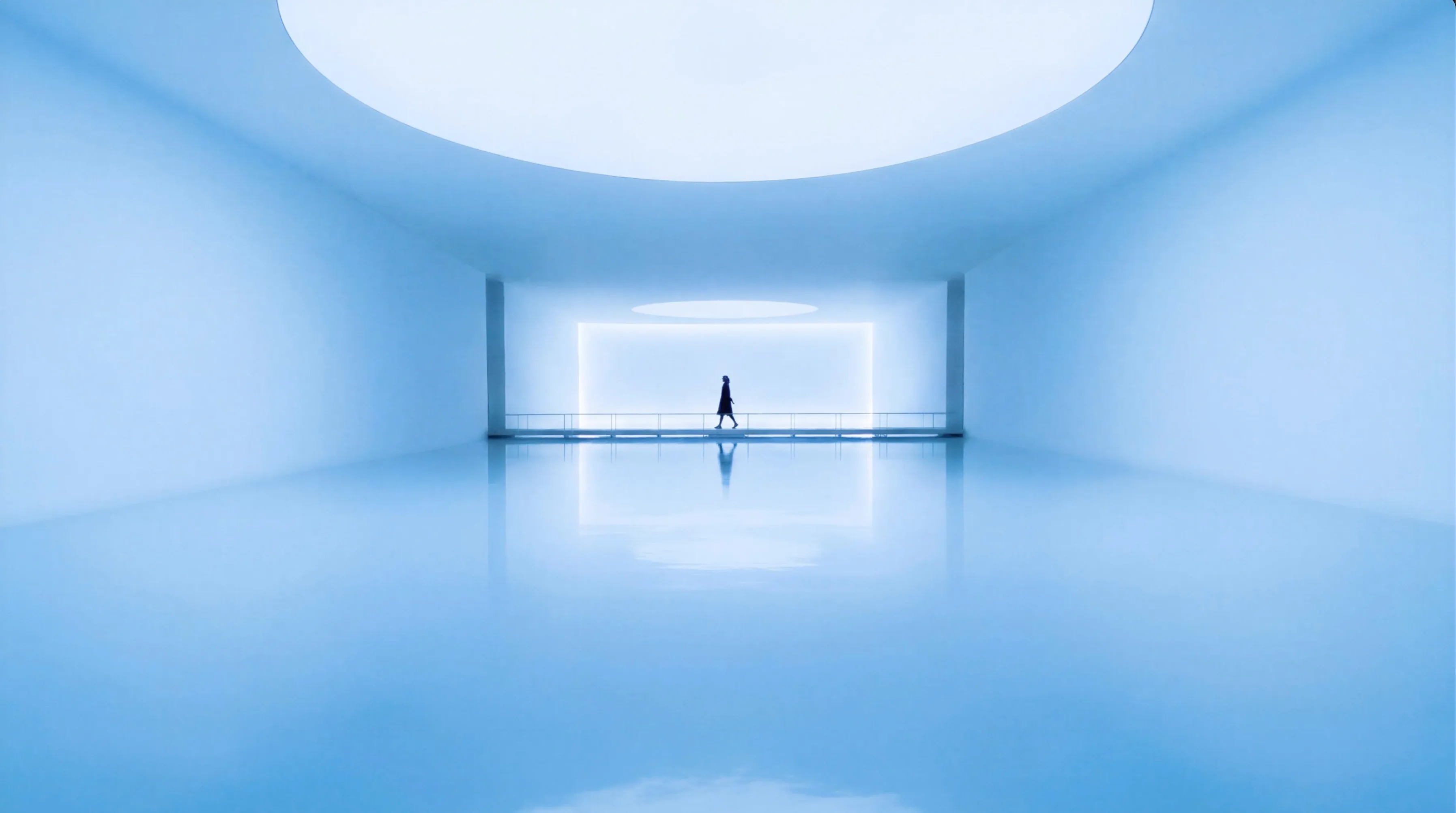Video showing a woman in the distance walking on a modern, minimalist, bright room